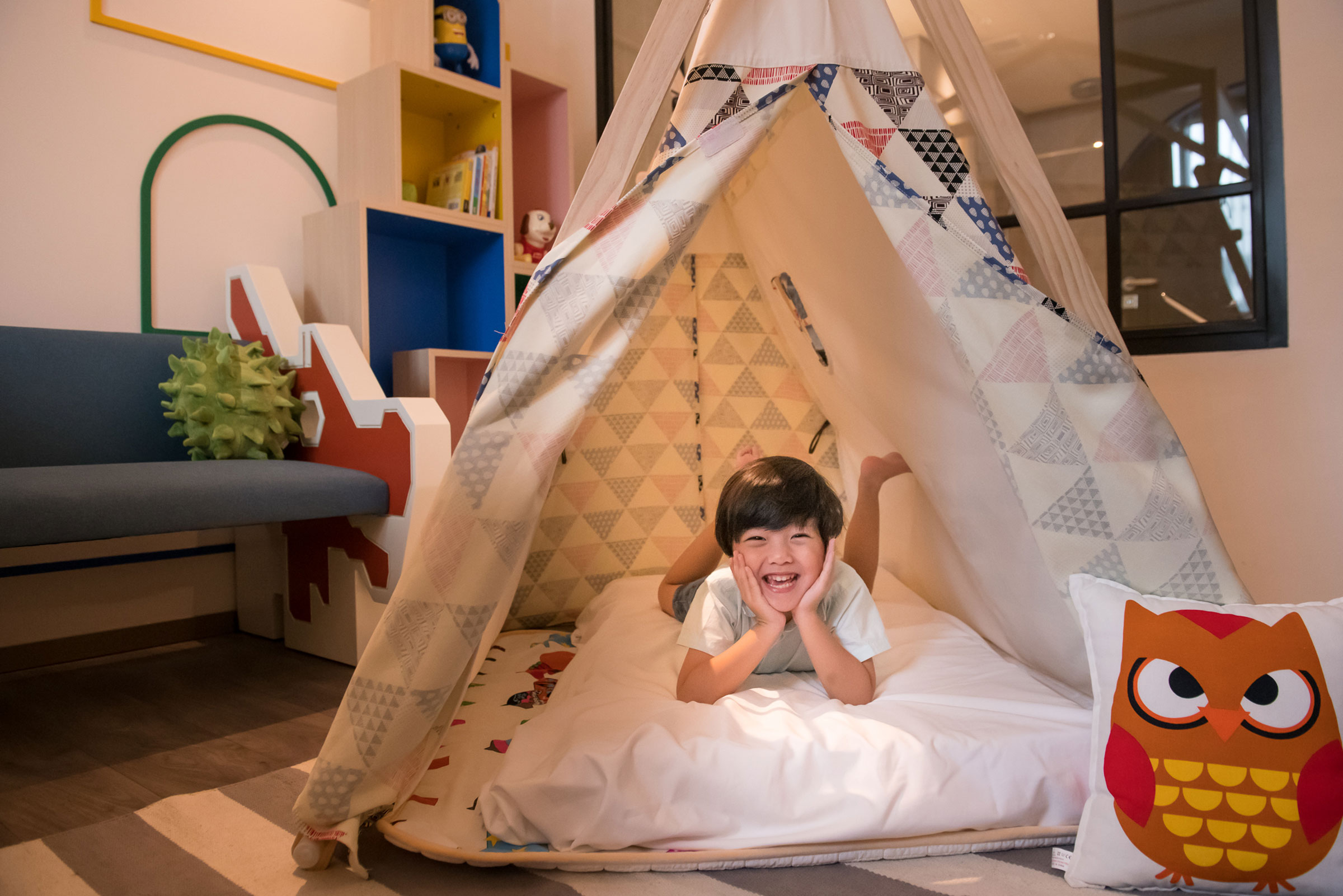 little boy playing in a teepee